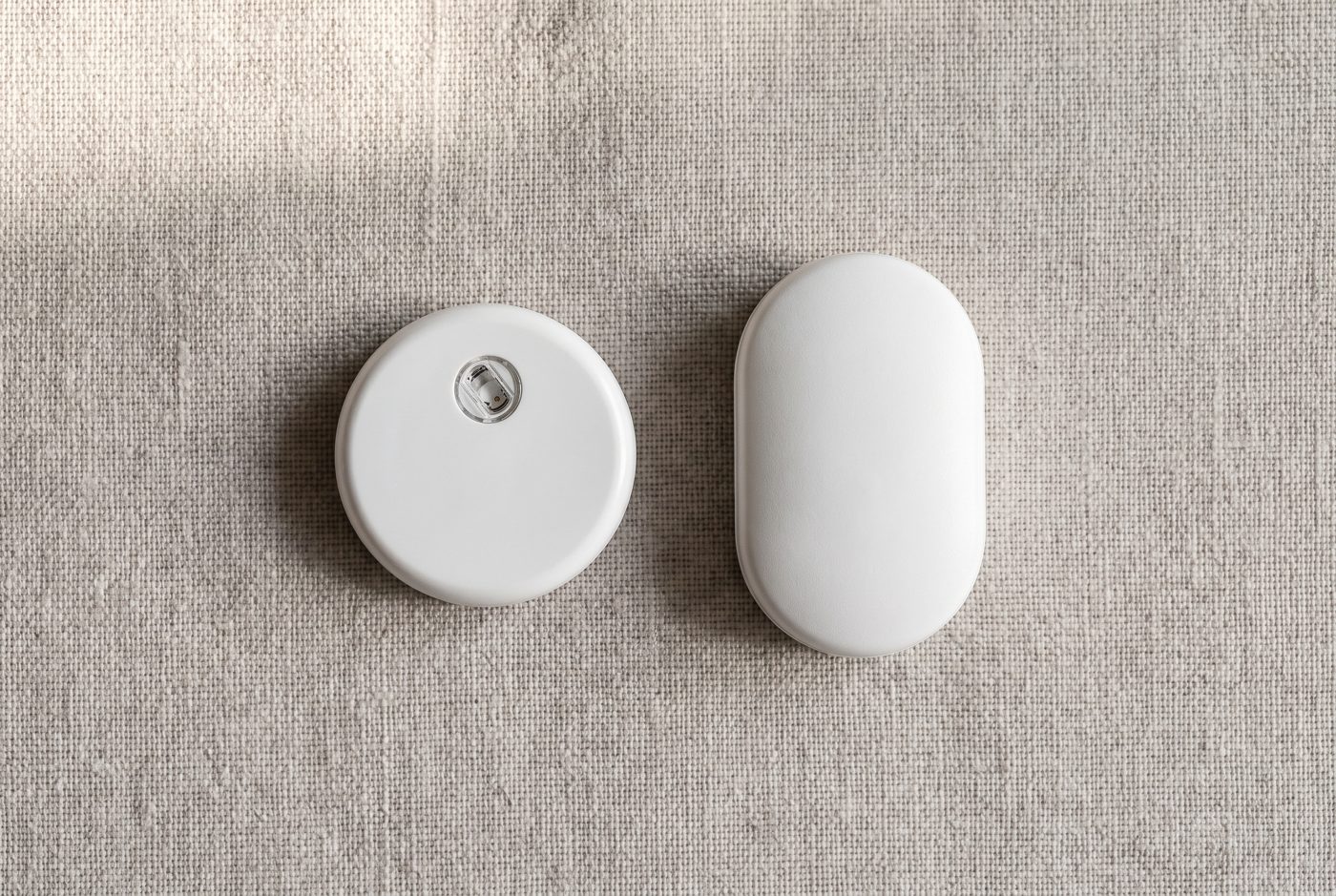 Ilustraci&oacute;n: el sensor QiTrax junto a un sensor ovalado m&aacute;s grande, del tipo del Sibionics GS1, sin marca